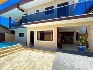 a house with a swimming pool and a balcony at Casa Centro com Piscina in Ubatuba