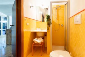 bagno giallo con lavandino e servizi igienici di MARCHE FULL EXPERIENCE-Apartments a Porto SantʼElpidio