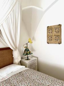 um quarto com uma cama e um candeeiro numa mesa de cabeceira em Al Bastione del Borgo Saraceno, Varigotti em Varigotti