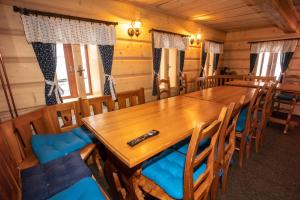 uma sala de jantar com uma longa mesa de madeira e cadeiras em Apartmány Javořinka em Pec pod Sněžkou