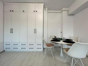 a dining room with white cabinets and a table and chairs at City View Apartament in Iaşi