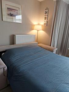 a bedroom with a bed with a blue blanket at Ensor 1 - centrum Oostende in Ostend
