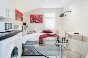 a white bedroom with a bed with a red blanket at 2-Bed Studio in Bedford-Hospital-VictoriaD in Bedford