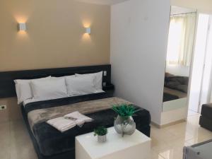a bedroom with a bed with a table and a mirror at Hotel Malka in São Paulo