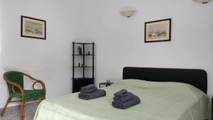 a bedroom with a bed with two towels on it at Casa Mirto in Alghero