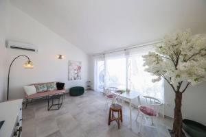 una sala de estar con una mesa y un árbol. en Apartment Fiorino en Zadar