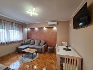 sala de estar con sofá y mesa en Apartman Drinić en Sombor