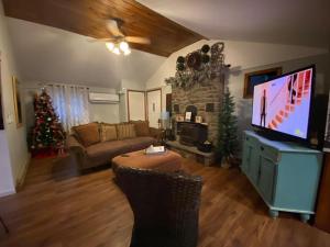 a living room with a television and a christmas tree at Peaceful Gateway to Island Creek Cottage in East Stroudsburg