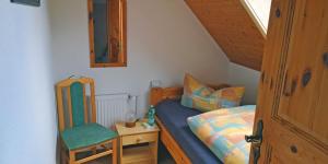 ハイルバート・ハイリゲンシュタットにあるIm Herzen Deutschlands entspannenの小さなベッドルーム(ベッド1台、椅子付)