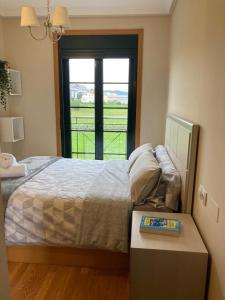 1 dormitorio con cama, ventana y mesa en FOZ II PLAYAS en Foz