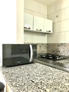 a kitchen with a microwave on a counter at Flat por temporada in São José da Coroa Grande