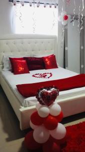 1 dormitorio con 1 cama con almohadas rojas y blancas en Hostal Sabanero en Barranquilla