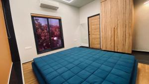 ein Schlafzimmer mit einem blauen Bett und einem Fenster in der Unterkunft VSP's Villa - Kensville Golf Living in Nānodra