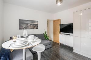 a living room with a white table and a couch at 1BR Victorian House near Bedford City Centre in Bedford