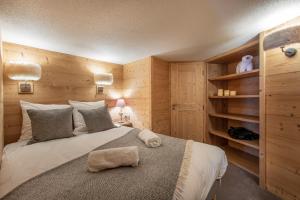 ヴァル・トランスにあるVal Thorens - Cosy Duplex avec Vue Silveralp 338の木製の壁のベッドルーム1室(大型ベッド1台付)