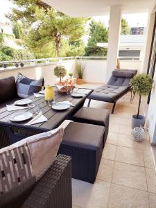 een patio met een tafel en stoelen op een balkon bij NewHome Nicole Premantura in Premantura