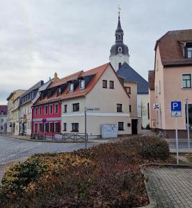 une rangée de bâtiments avec une église en arrière-plan dans l'établissement Ferienhaus Polly, à Taucha