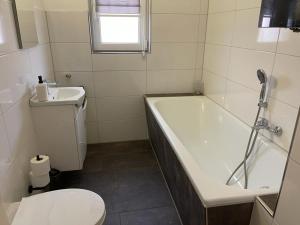 a bathroom with a tub and a toilet and a sink at POLAT Apartments 2 in Essen