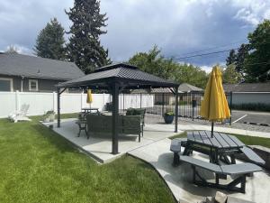 a gazebo with two picnic tables and a yellow umbrella at North Idaho Inn in Coeur d'Alene +7 photos