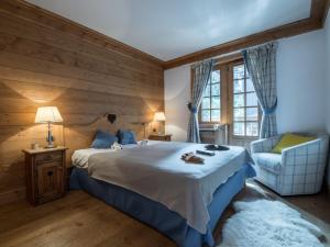 ein Schlafzimmer mit einem großen Bett und einem Stuhl in der Unterkunft Superbe Duplex 100m² au cœur de Courchevel 1850, à 50m des pistes, 3 chambres, tout confort - FR-1-575-146 in Courchevel