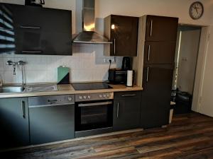 POLAT Apartments 3 في إيسن: مطبخ مع أجهزة ستانلس ستيل ودواليب سوداء
