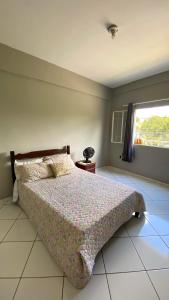 een slaapkamer met een bed en een raam bij Apartamento inteiro 2 quartos Wi-Fi in Montes Claros