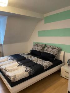 Schlafzimmer mit einem Bett mit schwarzweißer Bettwäsche und Kissen in der Unterkunft POLAT Apartments 5 in Essen