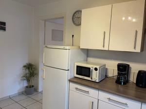 eine Küche mit einem weißen Kühlschrank und einer Mikrowelle in der Unterkunft POLAT Apartments 5 in Essen