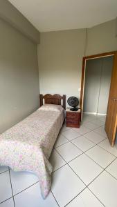 een slaapkamer met een bed en een spiegel bij Apartamento inteiro 2 quartos Wi-Fi in Montes Claros