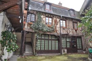 Ein altes Gebäude mit vielen Fenstern in der Unterkunft le vieux relais in Cosne-Cours-sur-Loire