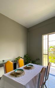 Apartamento inteiro 2 quartos Wi-Fi في مونتيس كلاروس: طاولة طعام مع طاولة بيضاء من قماش وكراسي