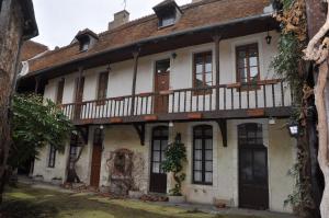 Una casa antigua con un balcón encima. en le vieux relais en Cosne-Cours-sur-Loire
