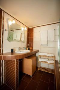 y baño con lavabo, espejo y toallas. en Retro seaside resort en La Canea