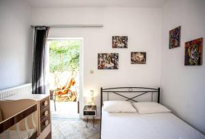 um quarto com uma cama e uma janela em Retro seaside resort em Chania Town
