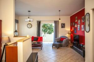 una sala de estar con paredes rojas y un sofá y una silla rojos. en Retro seaside resort en La Canea