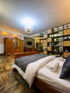 Shirbakyan Boutique Hotel & Apartments في يريفان: غرفة نوم بسرير كبير وثريا