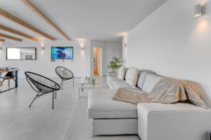 una sala de estar blanca con un sofá blanco y sillas en Calma Paraiso, en Playa Paraiso