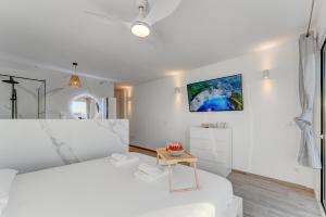 Dormitorio blanco con cama blanca y mesa en Calma Paraiso, en Playa Paraiso