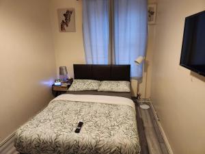 2-bedroom flat in Cutty-Sark, Greenwich ! في لندن: غرفة نوم صغيرة بها سرير وتلفزيون
