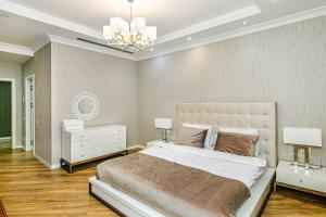 Un dormitorio con una cama grande y una lámpara de araña. en Isr Baku Family hotel apartment 4 bedroom en Baku