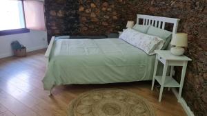 - une chambre avec un lit et une table avec une lampe dans l'établissement Casa do Adro da Igreja Velha, à Janeiro de Cima