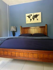 sypialnia z drewnianym łóżkiem i niebieską ścianą w obiekcie CS Domaine Garden Villa - 2 Bedrooms w mieście Port Antonio