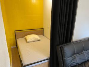 małe łóżko z poduszką w pokoju w obiekcie A Narbonne studio quartier Horte neuve w mieście Narbona