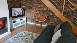 a living room with a fireplace and a tv at Casa do Adro da Igreja Velha in Janeiro de Cima