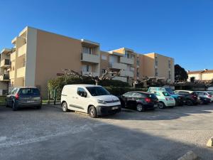parking z samochodami zaparkowanymi przed budynkiem w obiekcie A Narbonne studio quartier Horte neuve w mieście Narbona