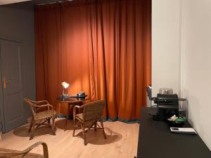 a room with an orange curtain and a table and chairs at Ritorno alle origini Suites in Milan