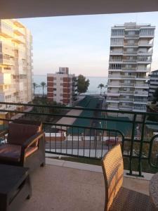 a balcony with chairs and a view of a city at Apartamento con vistas al mar y buena ubicación in Benicàssim