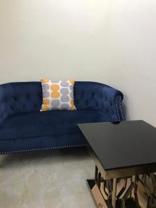 a blue couch sitting in a living room with a table at Lux Suites Dennis Pritt studio Apartments Kilimani in Nairobi