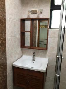 uma casa de banho com um lavatório e um espelho em Lux Suites Dennis Pritt studio Apartments Kilimani em Nairobi