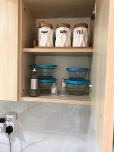 uma prateleira de cozinha com tigelas e sacos de chá em Lux Suites Dennis Pritt studio Apartments Kilimani em Nairobi